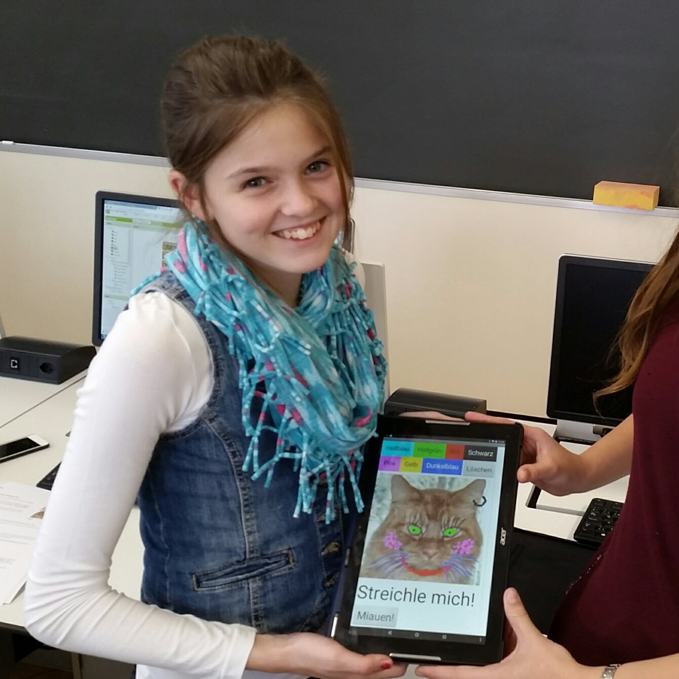 Foto: Mädchen zeigt stolz ihre selbst programmierte 
                        App zum Zeichnen auf Bildern