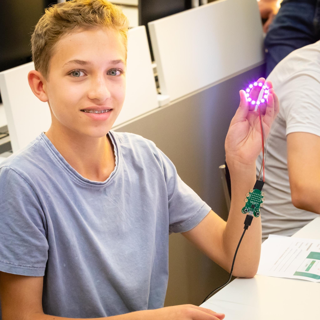 Foto von der Herstellen des LightBags: 
                        strahlender Knabe hält leuchtenden LED-Ring in der Hand