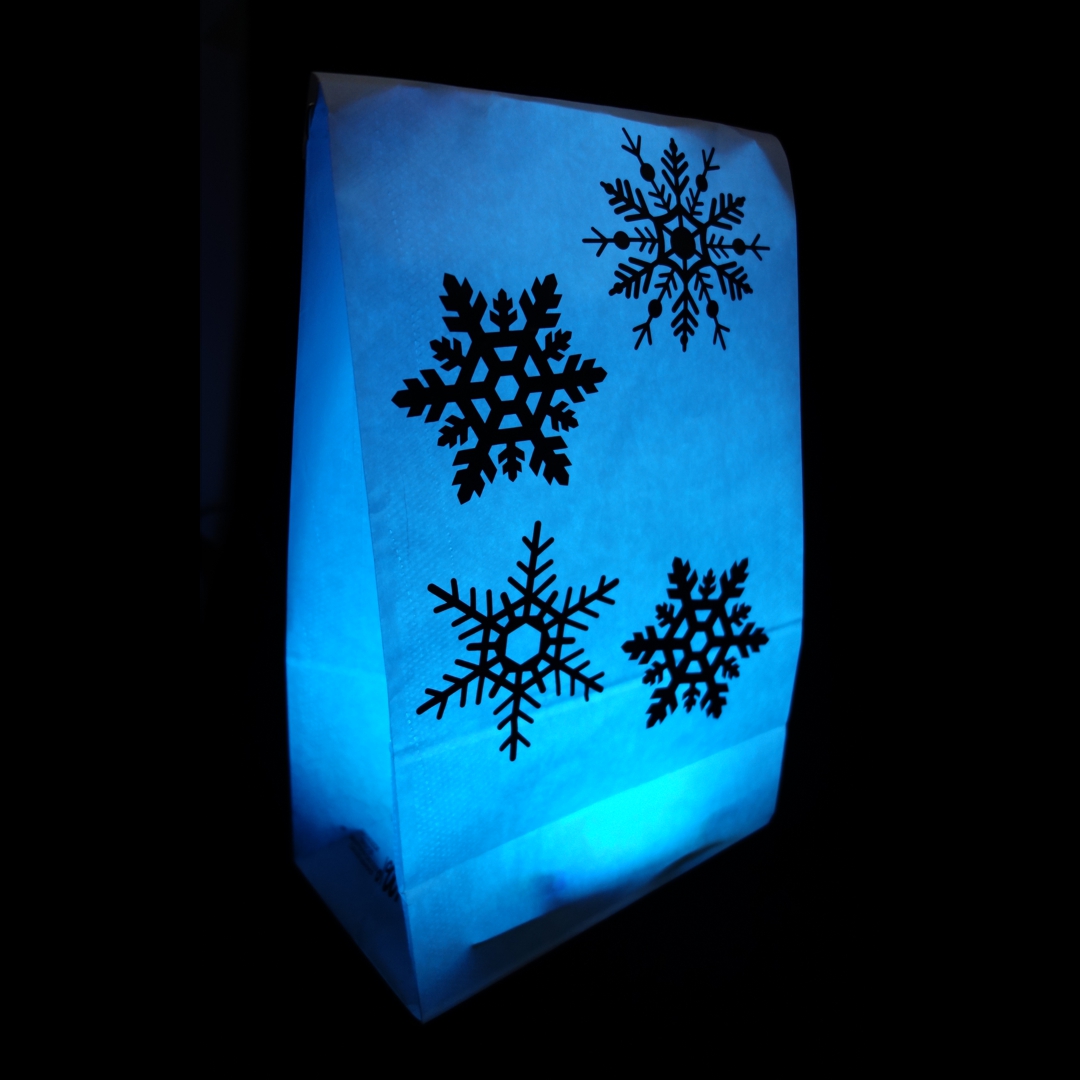 Foto einer LightBag-Dekoration: vier unterschiedliche
                       Schneeflocken aufgeklebt auf einem blau leuchtenden LlightBag
